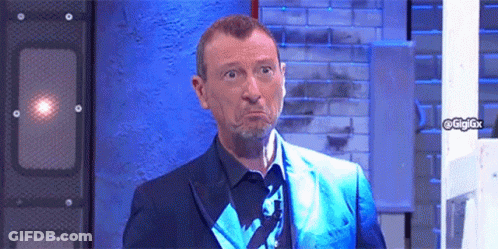 Man In Blue Suit Making Funny Face In Front Of Brick Wall GIF