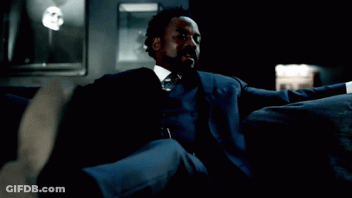 Man In Blue Suit Sitting On Couch GIF
