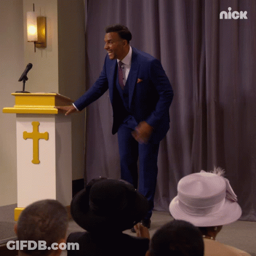 Man In Blue Suit Standing By Podium With Cross GIF