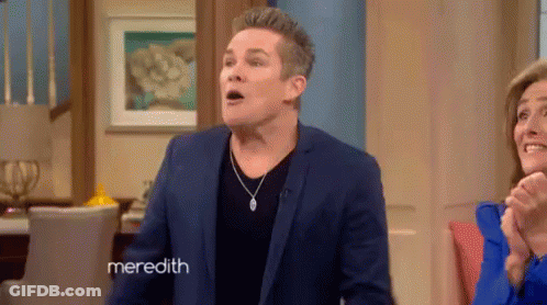 Man In Blue Suit Standing In Front Of Woman And Meredith Sign GIF