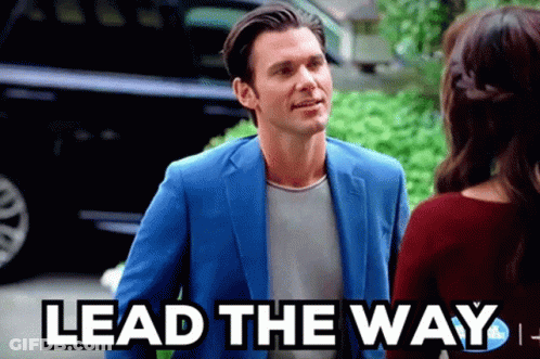 Man In Blue Suit Talks To Woman Saying Lead The Way GIF