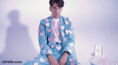 Man In Blue Suit With Hearts GIF