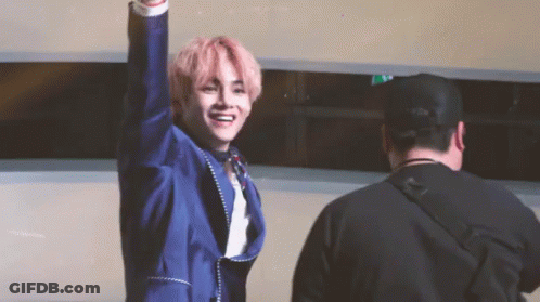 Man In Blue Suit With Pink Hair Raising Arm GIF