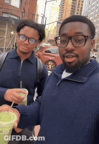 Man In Blue Sweater Holding Green Cup With Letter B GIF