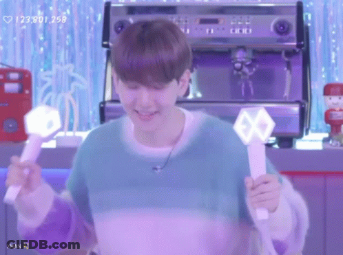Man In Blue Sweater Holding Light Stick With Exo Logo GIF