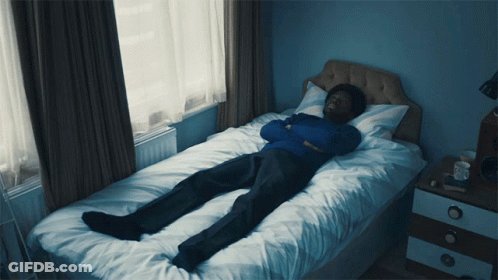 Man In Blue Sweater Lying On Bed GIF