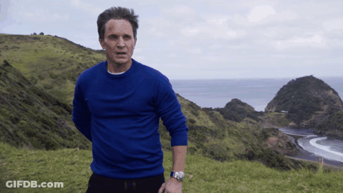 Man In Blue Sweater Overlooking Ocean GIF
