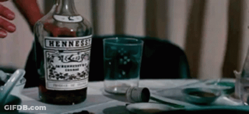 Man In Blue Sweater Sitting At Table With Wine Bottle GIF