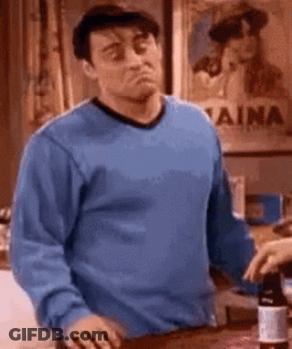 Man In Blue Sweater Sitting At Table With Wine Bottle GIF