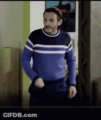 Man In Blue Sweater Standing In Doorway GIF