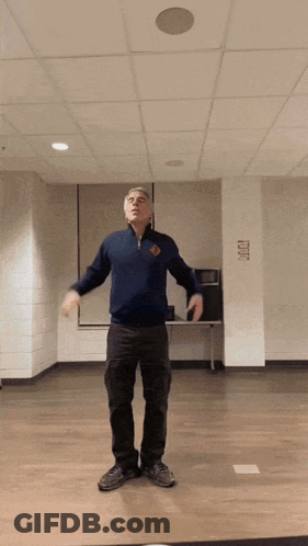 Man In Blue Sweater With Exit Sign GIF