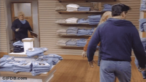 Man In Blue Sweatshirt Walking Through Store GIF