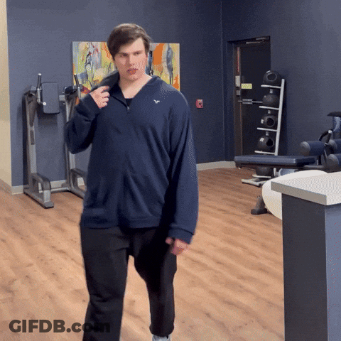 Man In Blue Sweatshirt With White Eagle Walking In Gym GIF
