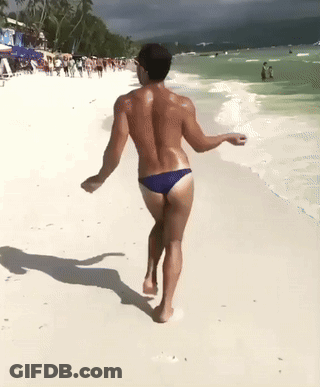 Man In Blue Swim Trunks Walking Beach GIF