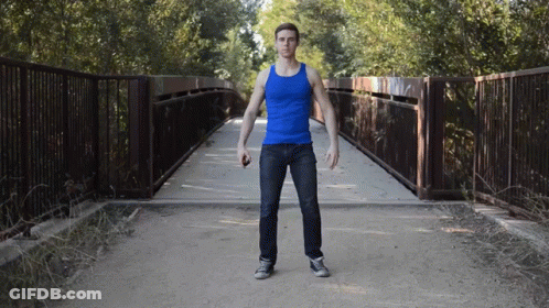 Man In Blue Tank Top Standing By Bridge GIF