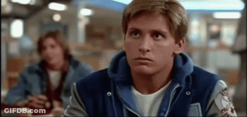Man In Blue Varsity Jacket Sitting At Restaurant Looking Up GIF