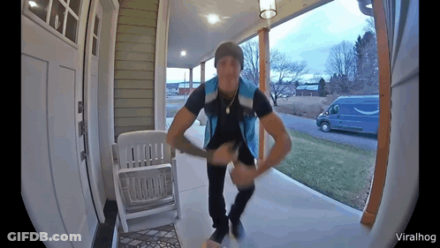 Man In Blue Vest On Porch Next To White Rocking Chair GIF