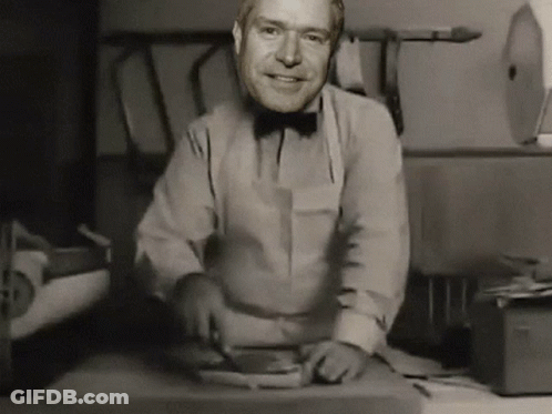 Man In Bow Tie Smiling While Cutting Meat GIF