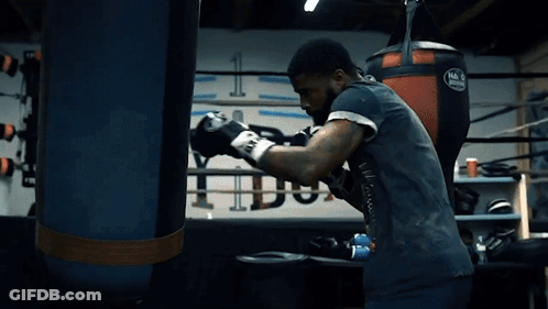Man In Boxing Gloves Standing In Front Of Mack Bag GIF