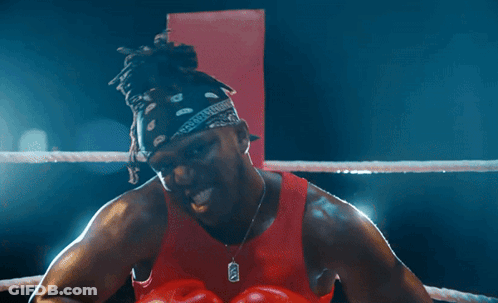 Man In Boxing Ring With Red Gloves And X Necklace GIF