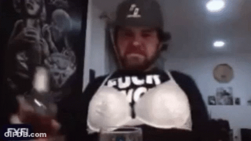 Man In Bra And Baseball Cap Holding Wine GIF