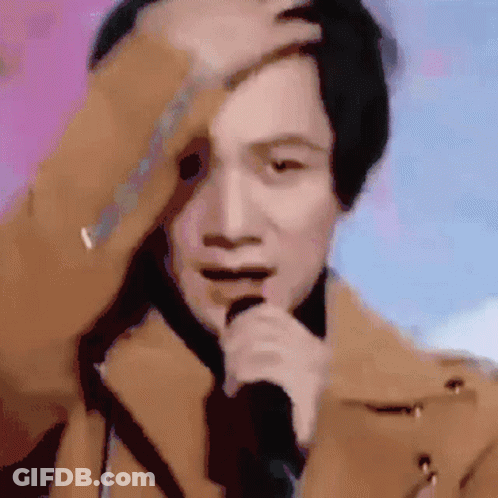 Man In Brown Coat Singing And Scratching Head GIF