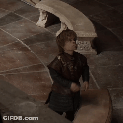 Man In Brown Coat Standing Before Stone Bench With Sword GIF