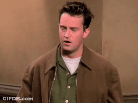 Man In Brown Jacket And Green Shirt Standing In Room GIF