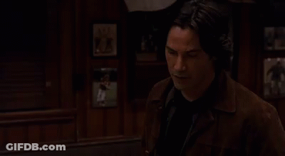 Man In Brown Jacket Beside Wall Portrait GIF
