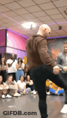 Man In Brown Jacket Dancing Before Crowd GIF