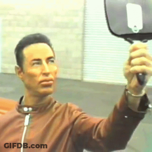 Man In Brown Jacket Holding Mirror GIF