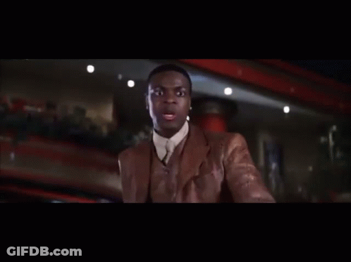 Man In Brown Jacket In Dark Room With Crowd GIF