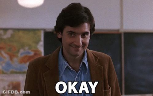 Man In Brown Jacket Saying Okay In Classroom GIF