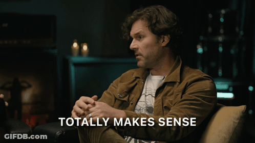 Man In Brown Jacket Sits On Couch Saying Totally Makes Sense GIF