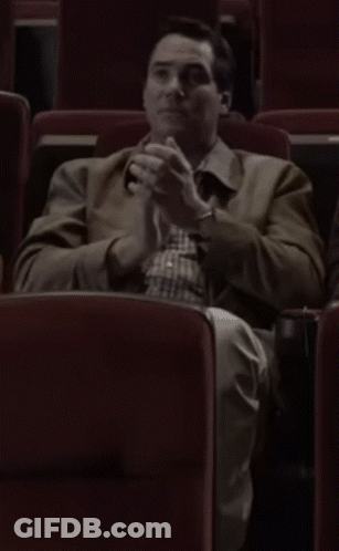 Man In Brown Jacket Sitting In Theater GIF