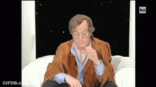 Man In Brown Jacket Sitting On White Couch With Rai GIF