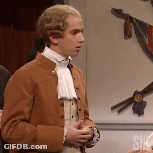 Man In Brown Jacket Standing In Front Of SNL Wall GIF