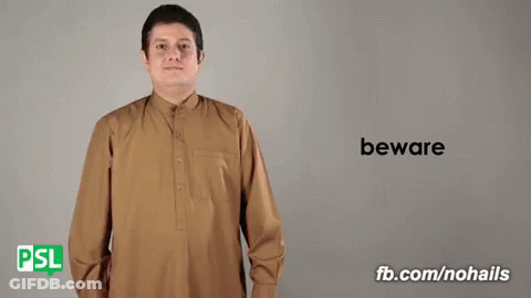 Man In Brown Shirt Saying Beware In Sign Language GIF