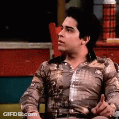 Man In Brown Shirt Sitting And Talking GIF