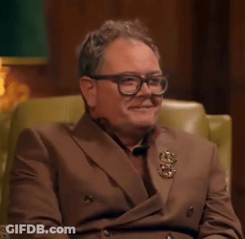 Man In Brown Suit And Glasses Smiling GIF