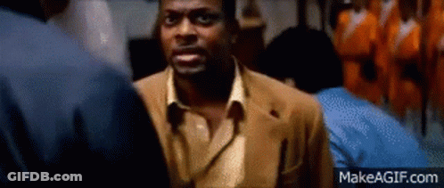 Man In Brown Suit Talking To Another Man In Dark Room GIF