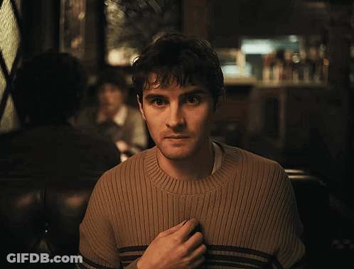 Man In Brown Sweater Looking At Camera GIF