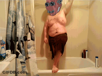 Man In Brown Towel Standing In Bathtub GIF