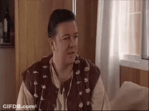 Man In Brown Vest Sitting By Window GIF