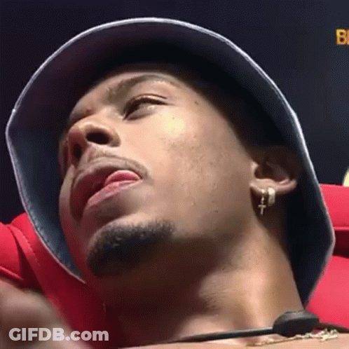 Man In Bucket Hat And Earrings Sitting In Chair GIF