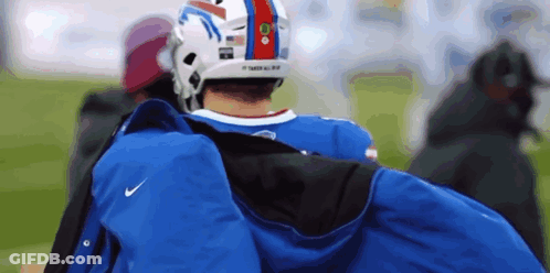 Man In Buffalo Bills Helmet Carrying Blue Jacket GIF