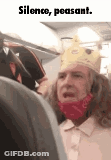 Man In Burger King Crown And Mask Sitting On Airplane GIF