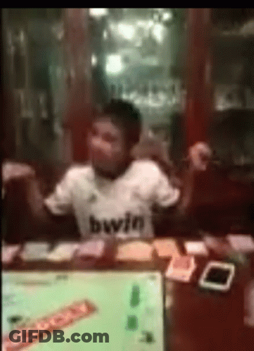 Man In Bwin Shirt Sitting With Monopoly Cards GIF