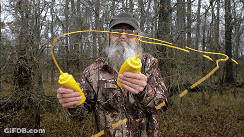 Man In Camo Jacket Holding Two Yellow Bottles GIF