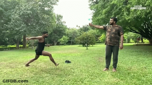 Man In Camo Shirt Throwing Frisbee Another Man Watches GIF